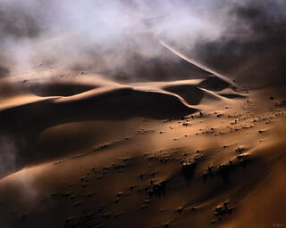 dappled light and fog above sand dunes in Sossusvlei, Namibia