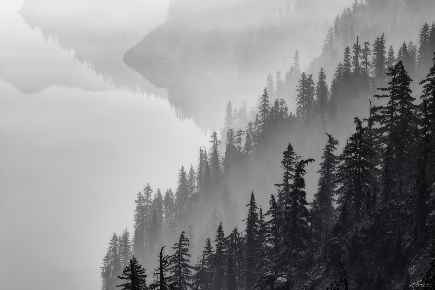 smoke weaving through the forest on the edge of crater lake in oregon