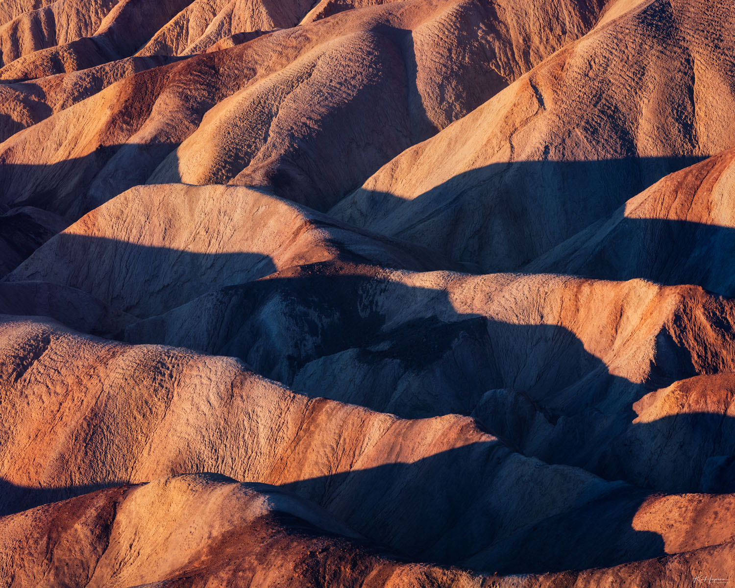 Soft morning light illuminating rolling hills in Death Valley, California. 