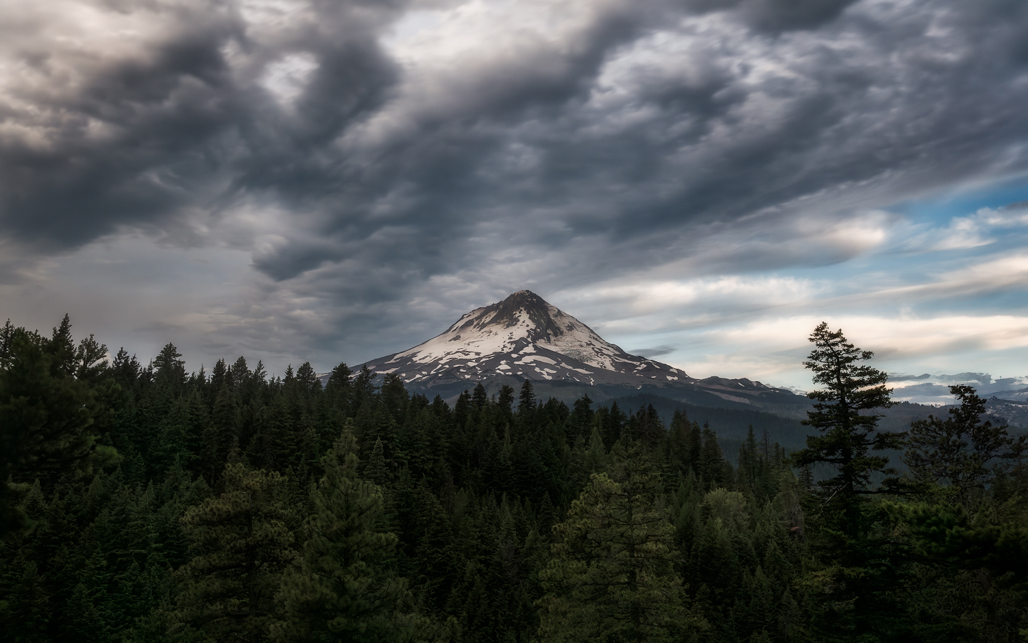 Dark clouds hovering over Mt. Hood at sunrise.