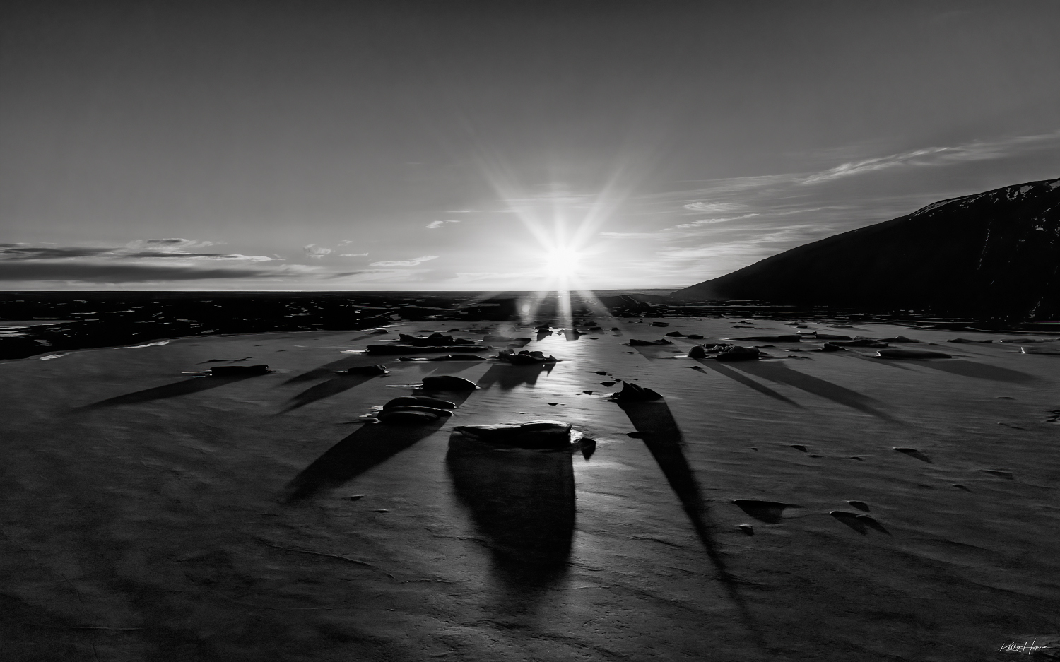 Black & White aerial image of large chucks of ice locked in place in a frozen lake. The sun was setting and casting long shadows...